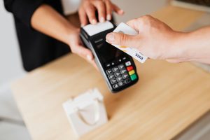 customer paying for goods via VISA card on eftpos terminal in store