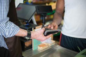 customer paying via eftpos terminal at local grocery store